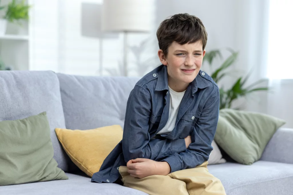um menino com dor de barriga por conta de uma doença causada pela água