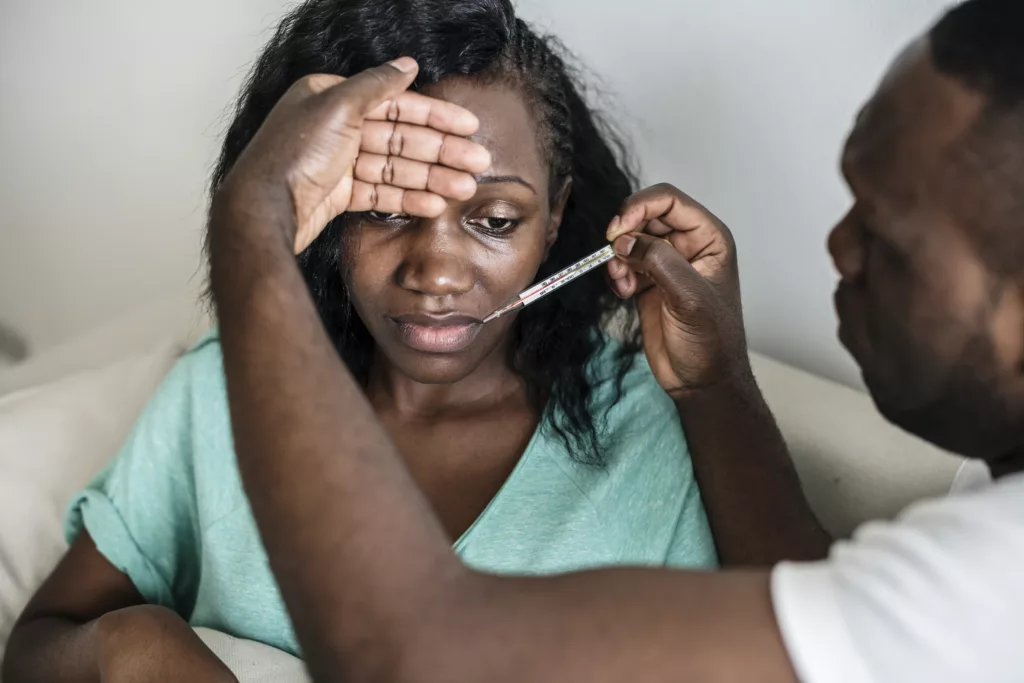 mulher com febre depois de tomar uma água contaminada